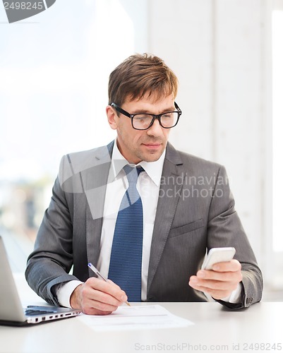 Image of businessman working with laptop and smartphone