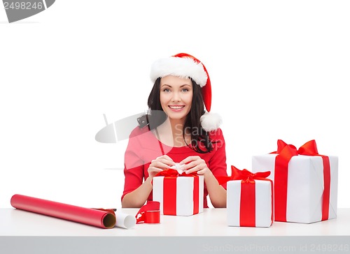 Image of woman in santa helper hat with many gift boxes