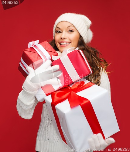 Image of woman in sweater and hat with many gift boxes