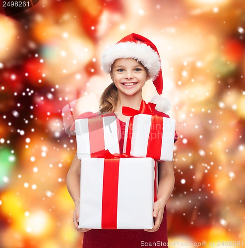 Image of girl in santa helper hat with many gift boxes