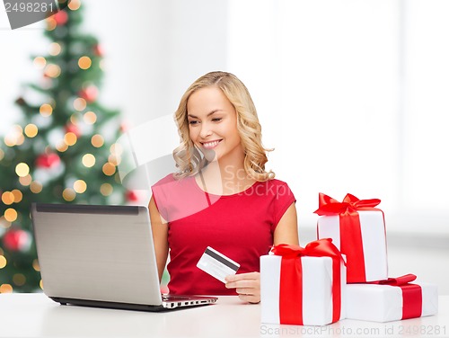 Image of woman with gifts, laptop computer and credit card