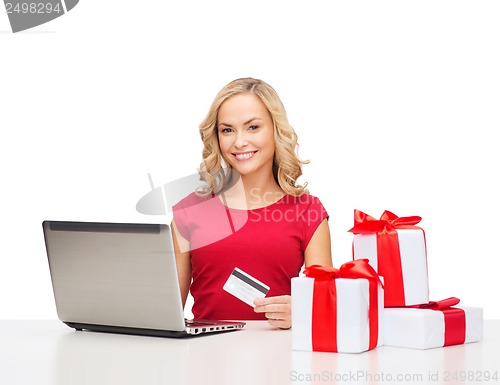 Image of woman with gifts, laptop computer and credit card