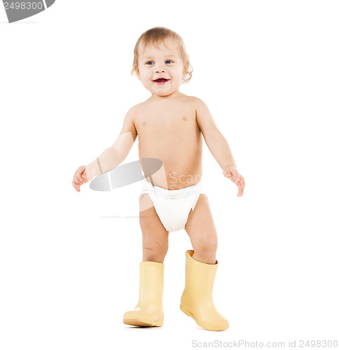 Image of cute little boy walking in big rubber boots