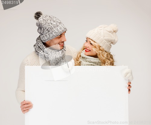 Image of couple in winter clothes with blank white board