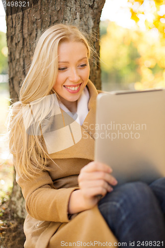 Image of woman with tablet pc in autumn park