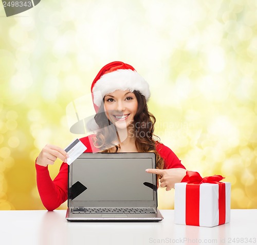Image of woman with gift, laptop computer and credit card