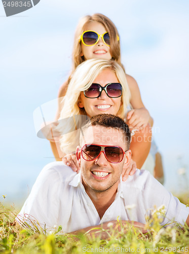 Image of happy family with blue sky and green grass