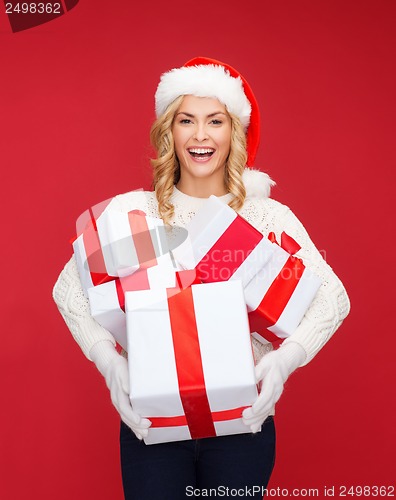 Image of woman in santa helper hat with many gift boxes