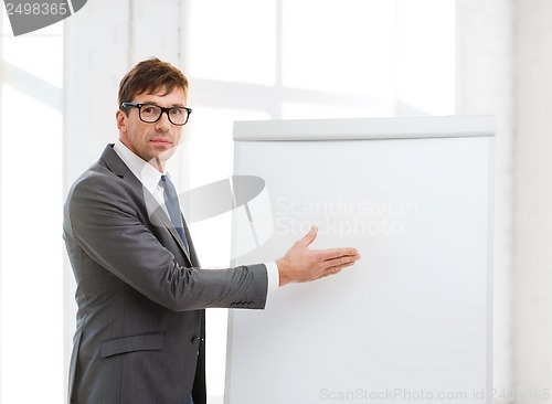 Image of businessman pointing to flip board in office