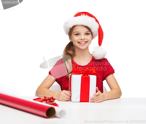 Image of smiling girl in santa helper hat with gift box