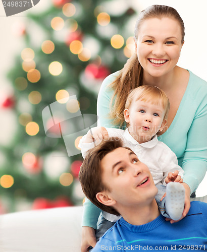 Image of happy parents playing with adorable baby