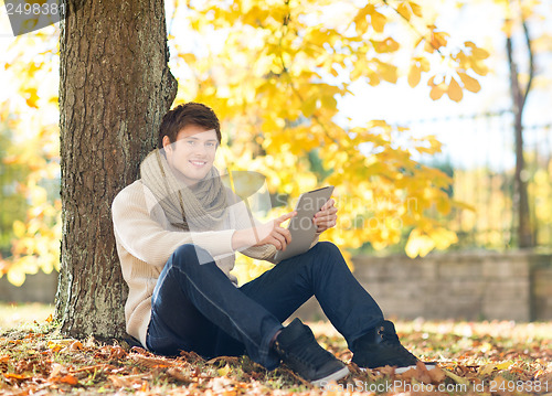 Image of man with tablet pc in autumn park