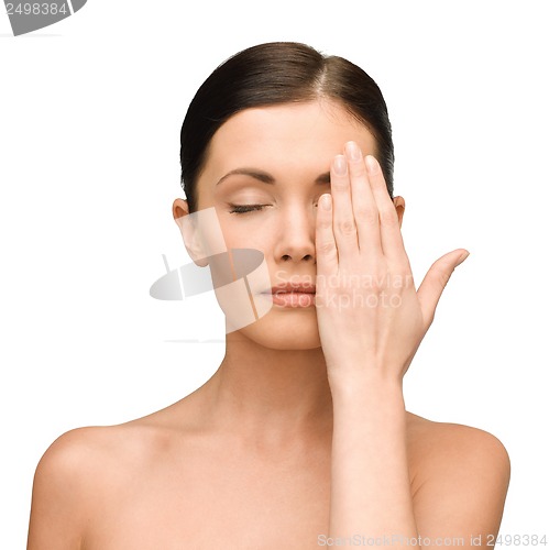Image of calm young woman covering face with hand