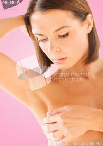 Image of woman checking breast for signs of cancer