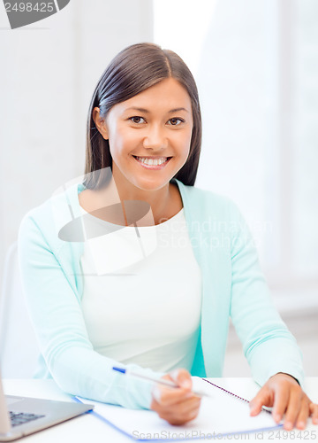 Image of asian businesswoman with laptop and documents