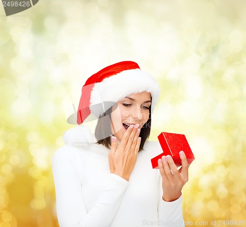 Image of surprised woman in santa helper hat with gift box