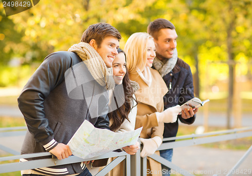 Image of couples with tourist map in autumn park