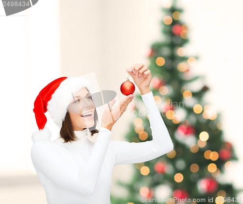 Image of woman in santa helper hat with christmas ball