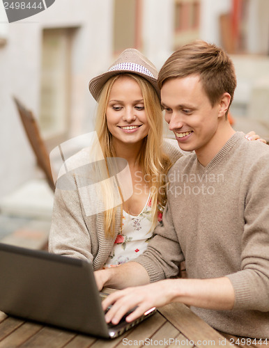 Image of couple with laptop in cafe