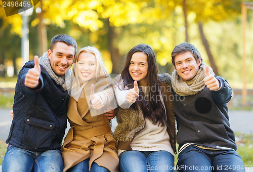 Image of group of friends having fun in autumn park