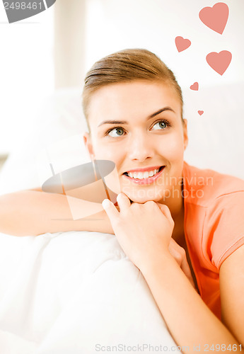 Image of happy woman in love dreaming at home