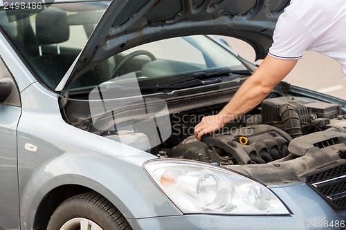 Image of man opening car bonnet