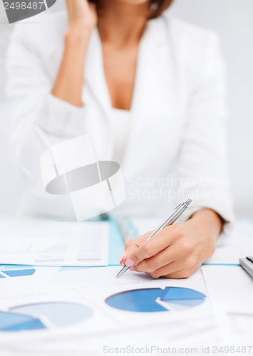 Image of woman with documents taking phone call