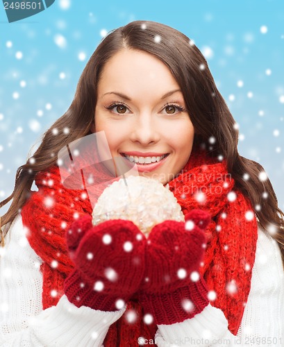 Image of woman in scarf and mittens with christmas ball