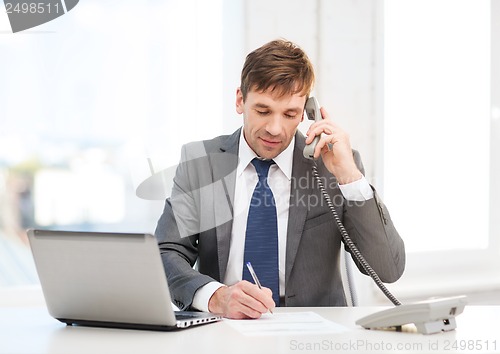 Image of businessman with laptop computer and phone