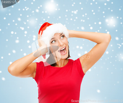 Image of surprised woman in santa helper hat