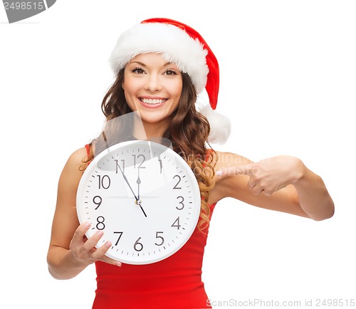 Image of woman in santa helper hat with clock showing 12