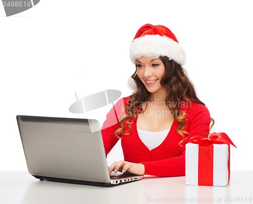 Image of woman with gift box and laptop computer