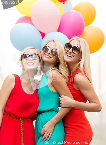 Image of beautiful girls with colorful balloons in the city