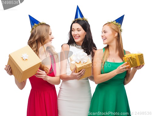 Image of three smiling women in blue hats with gift boxes