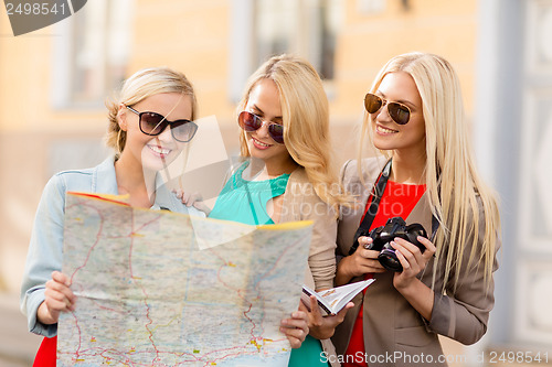 Image of beautiful women with tourist map in the city