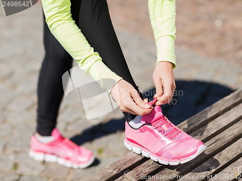 Image of runner woman lacing trainers shoes