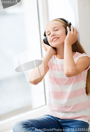 Image of little girl with headphones at home