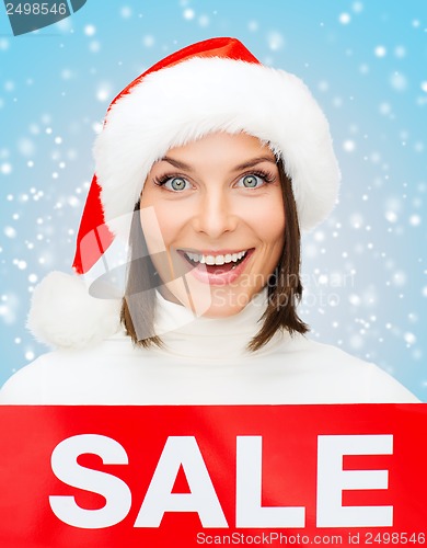 Image of woman in santa helper hat with red sale sign