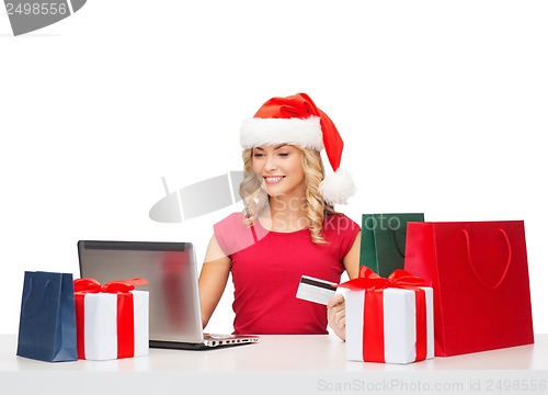 Image of woman with gifts, laptop computer and credit card