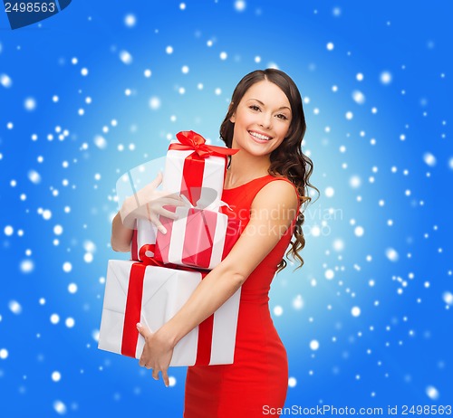 Image of smiling woman in red dress with many gift boxes