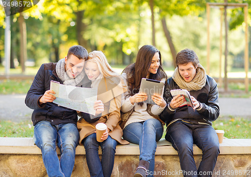 Image of couples with tourist map in autumn park