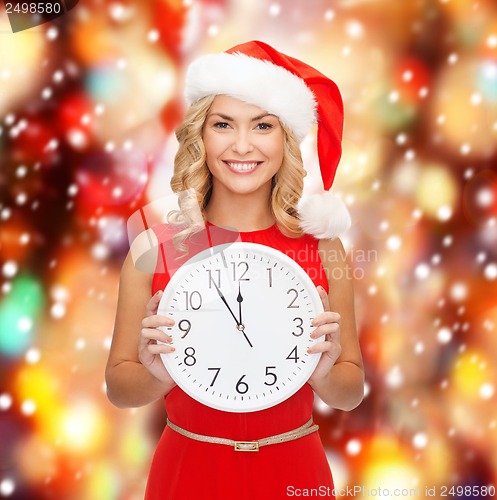 Image of woman in santa helper hat with clock showing 12