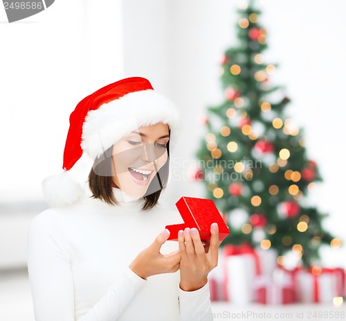Image of surprised woman in santa helper hat with gift box