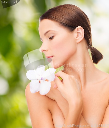 Image of relaxed woman with orchid flower
