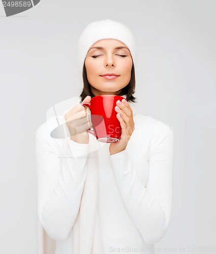 Image of woman in hat with red tea or coffee mug