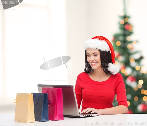 Image of woman with shopping bags and laptop computer