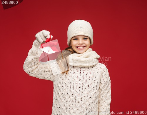 Image of girl in hat, muffler and gloves with jingle bells