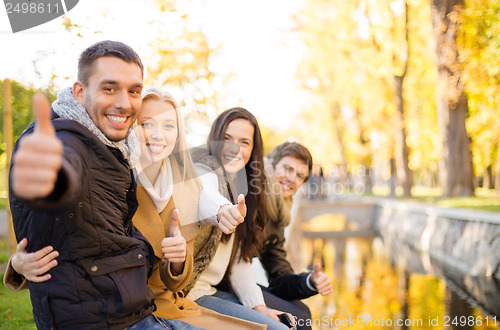 Image of group of friends having fun in autumn park