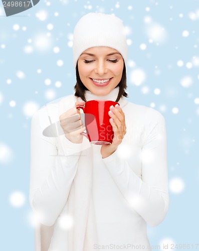 Image of woman in hat with red tea or coffee mug