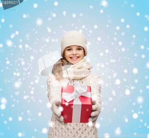 Image of girl in hat, muffler and gloves with gift box